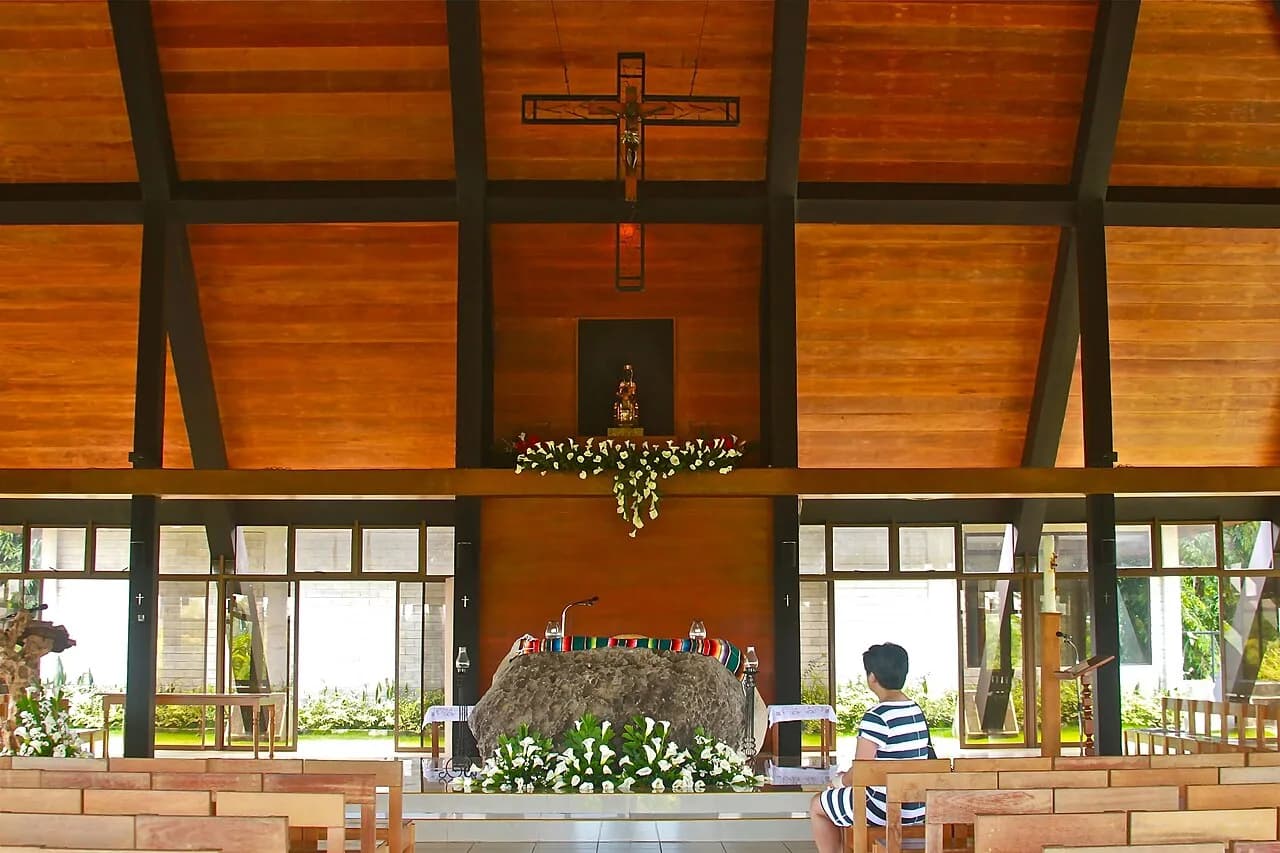 Warm timber ceiling, crucifix and altar inside the Monastery of the Transfiguration in Malaybalay
